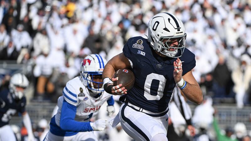 Penn State linebacker Dominic DeLuca returns an interception for a touchdown while being...